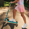 young girl riding jupiter kick scooter on a path