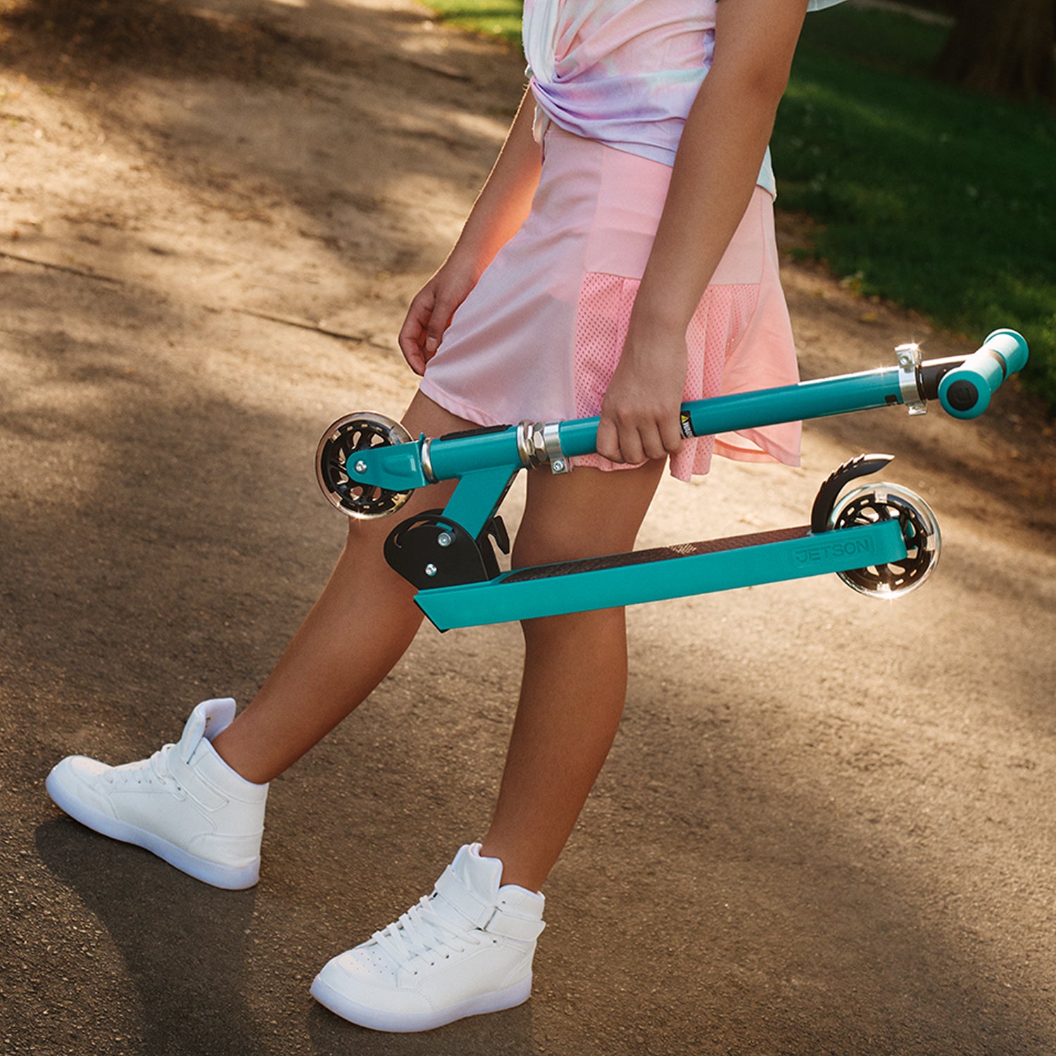 girl holding a folded jupiter kick scooter