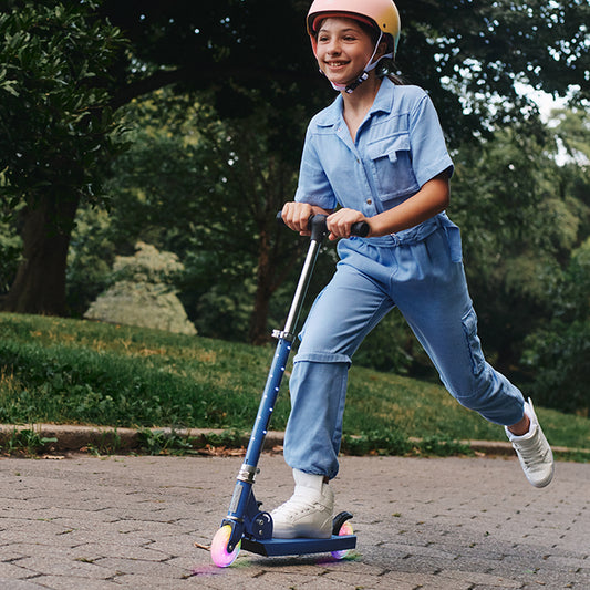 young kid riding blue moonbeam scooter