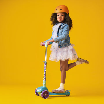 young girl riding three wheel kick scooter