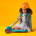 young girl folding the Little mermaid kick scooter while sitting on the ground