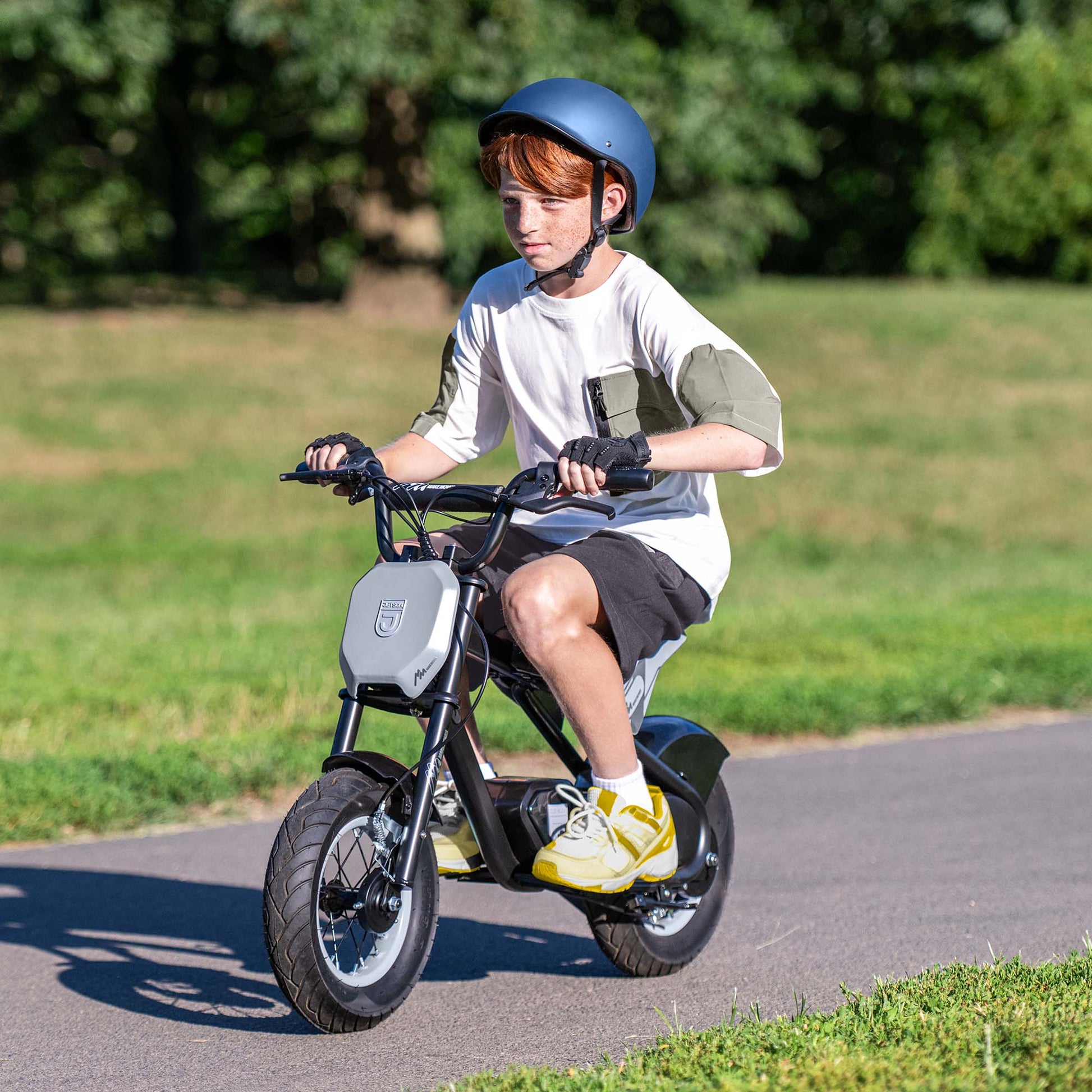 kid riding rio electric ride on through a park
