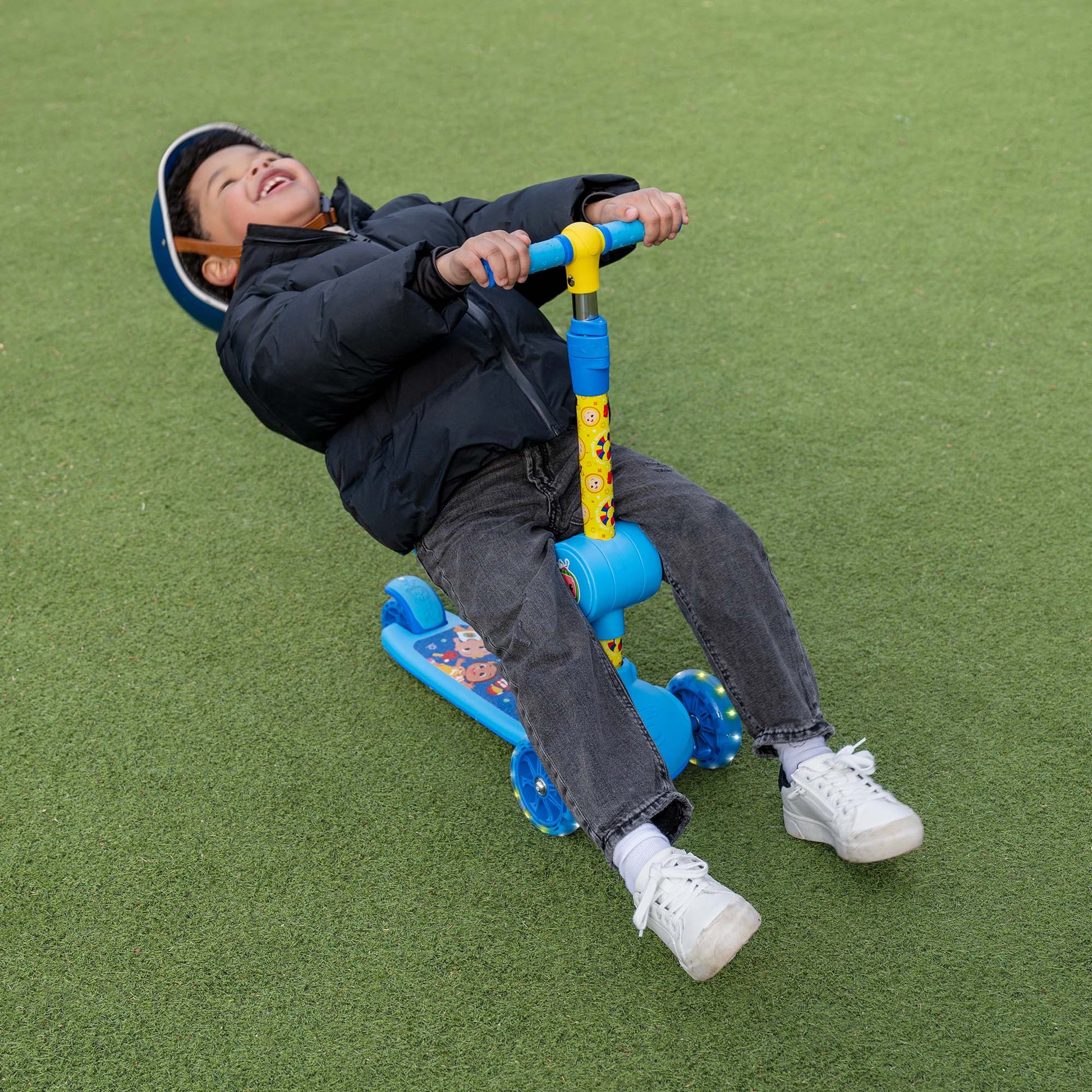 little kid sitting on cocomelon scooter seat