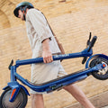 person carrying folded shield electric scooter
