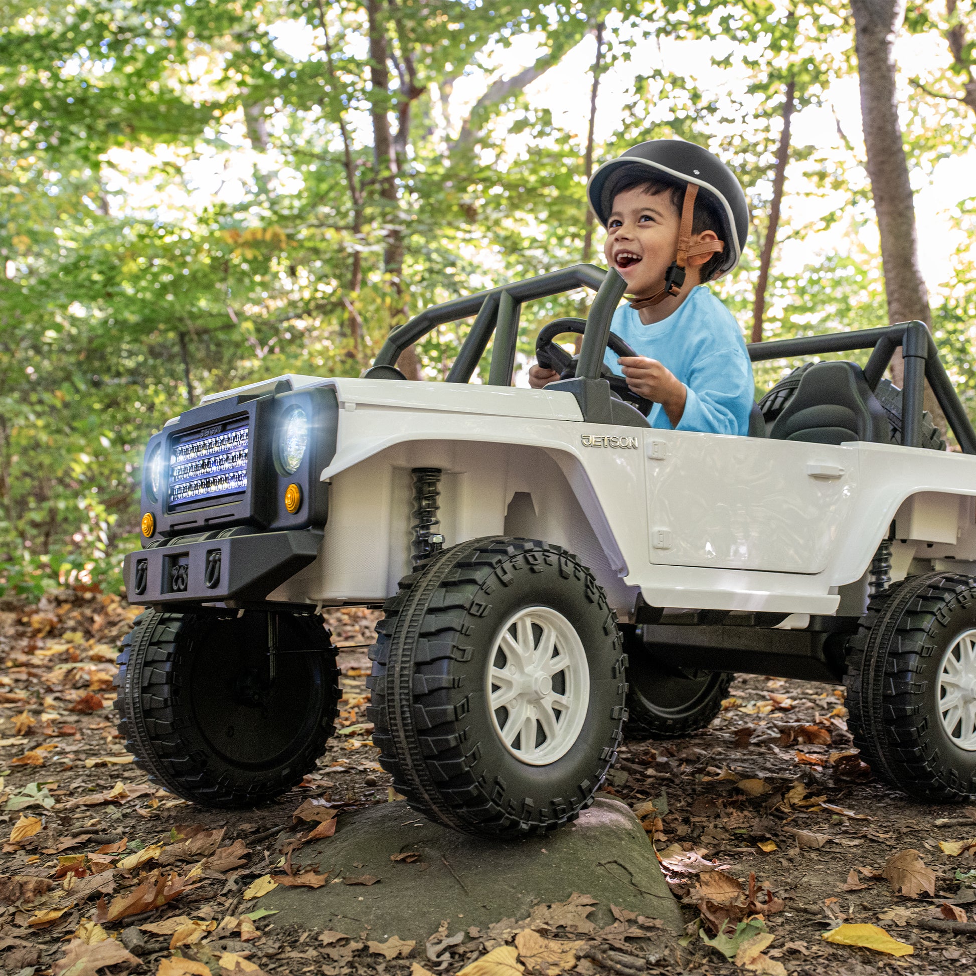 young boy driving vega ride-on in the woods