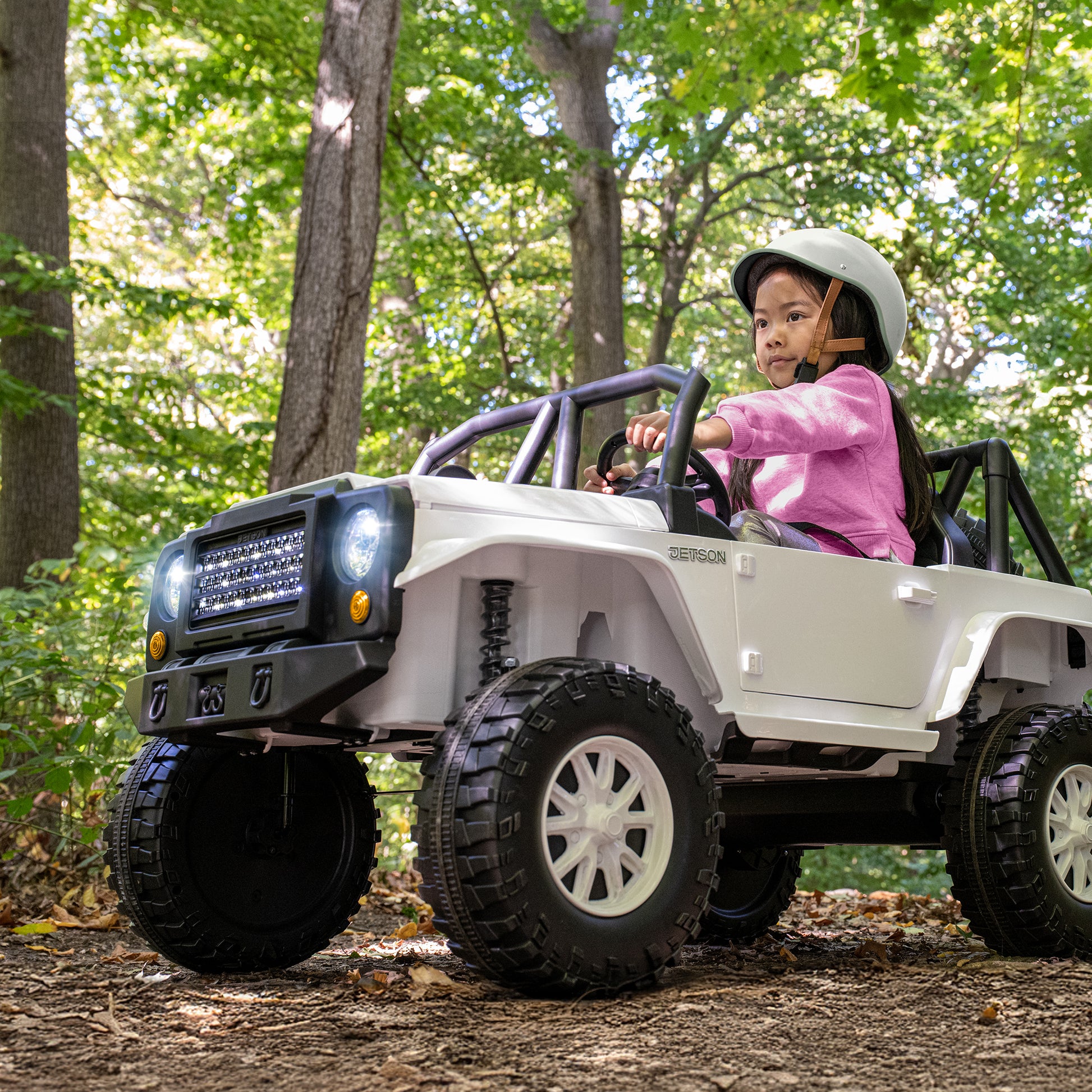 young girl driving vega ride-on in the woods