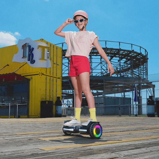 young person riding on the Flash hoverboard on a boardwalk