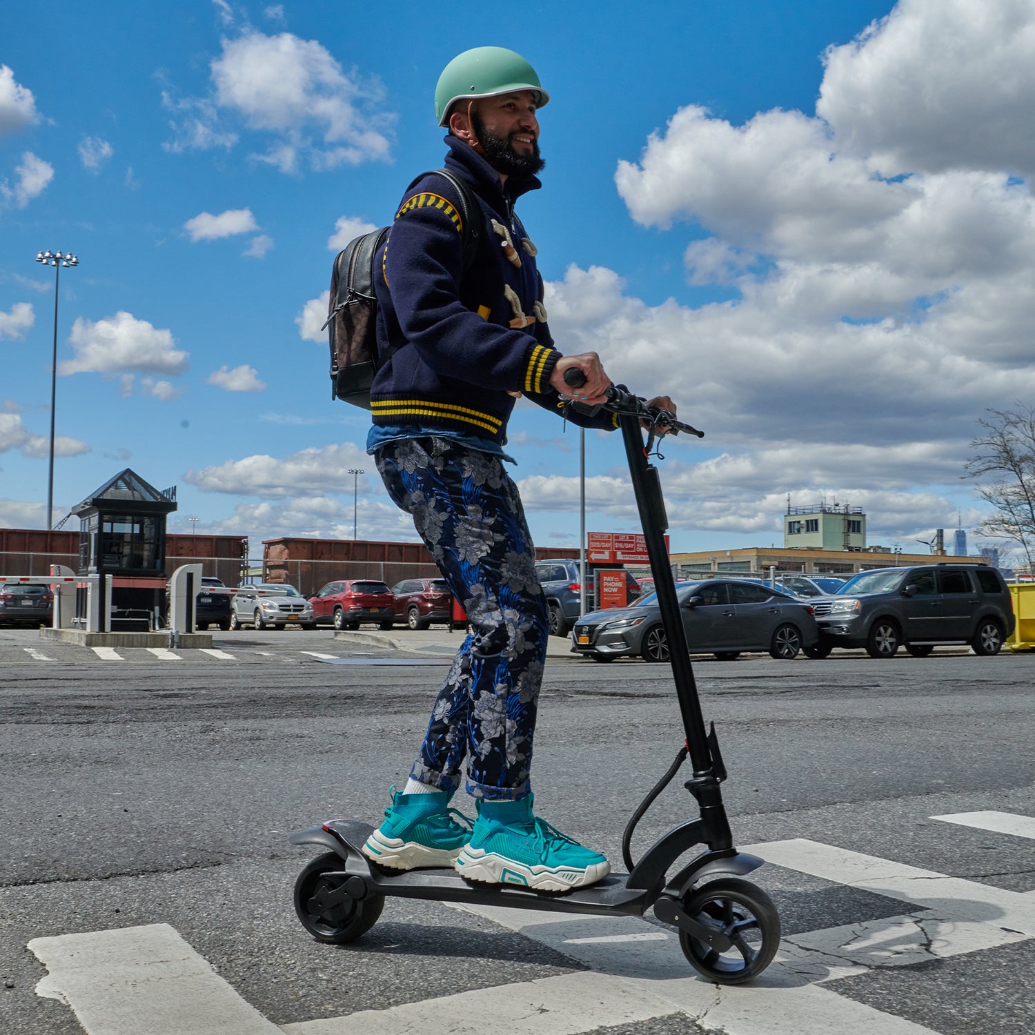 man smiling while making turn on e-scooter outside