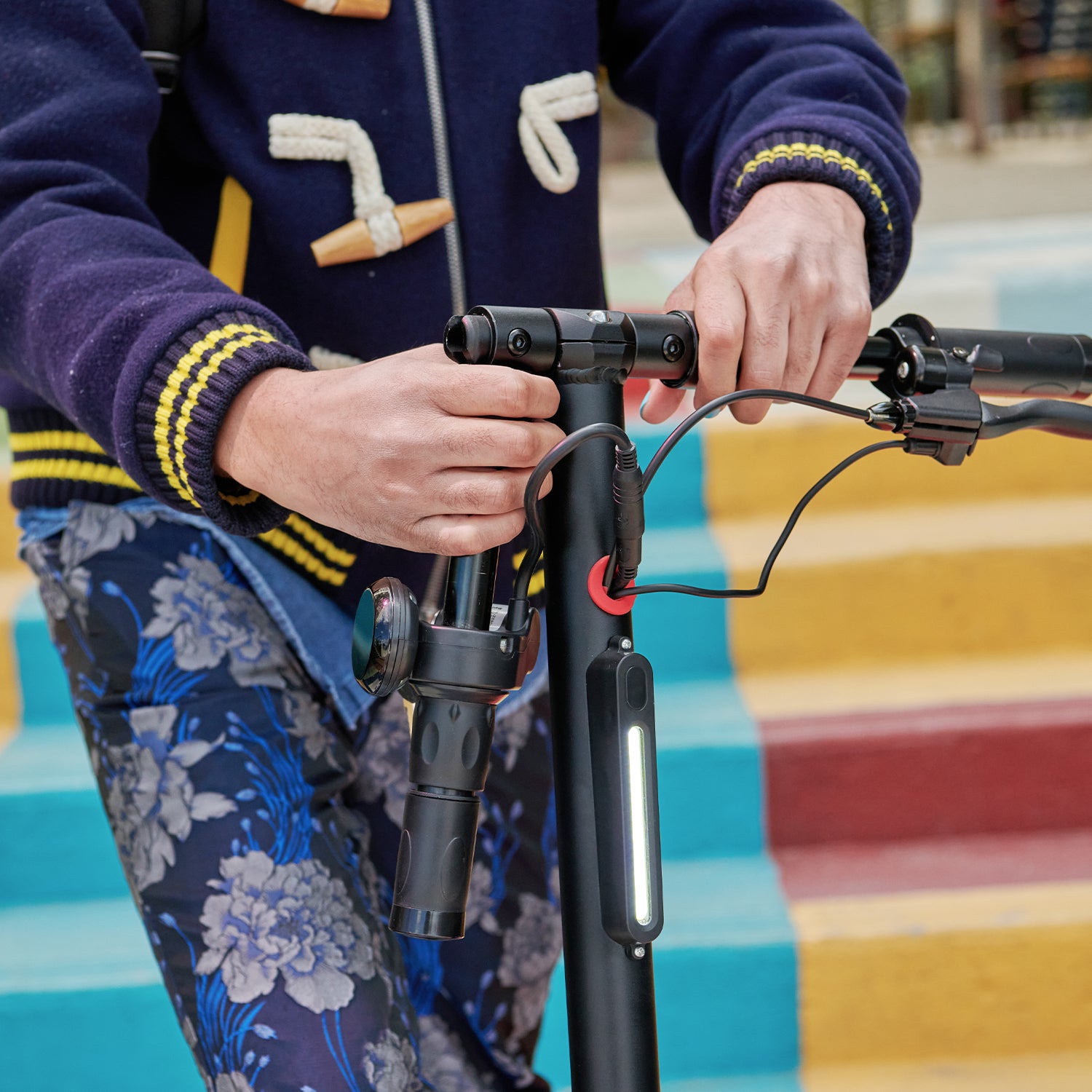 close up of person folding the handle bars of Globe e-scooter