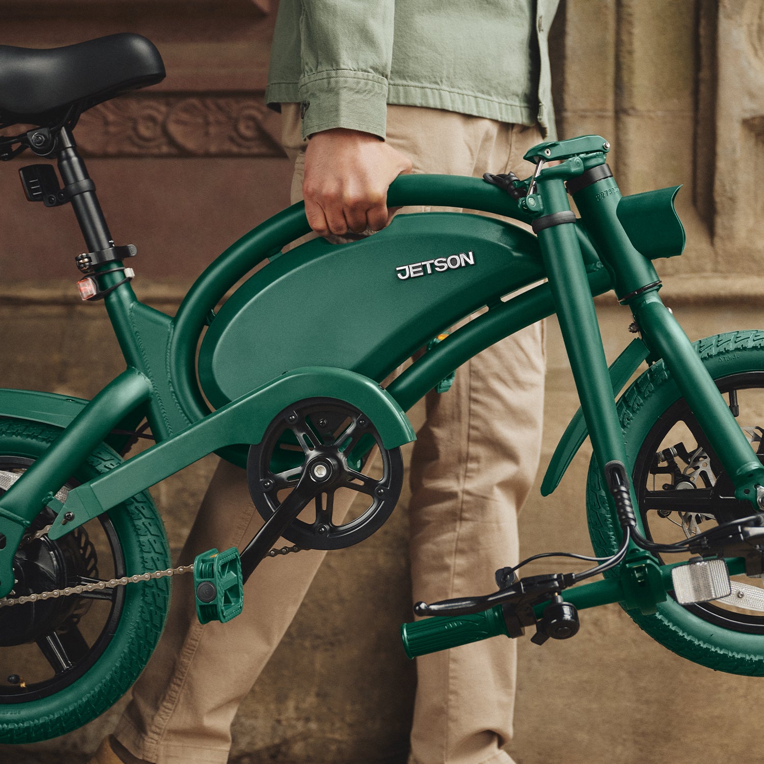 person carrying folded green Bolt Pro by the carrying handle