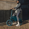 person with a helmet sitting on a blue Bolt Pro bike