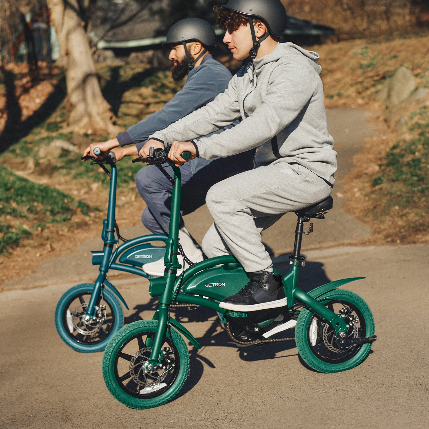 two people in helmets riding Bolt Pro bikes in a park