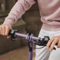 close up of slate Bolt handlebars with person's hand on the brake