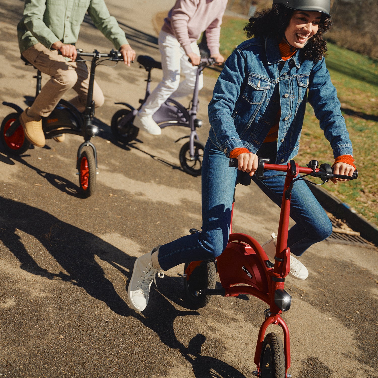 three people riding the Bolt through a park