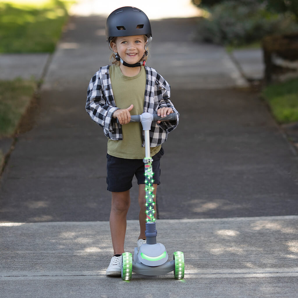 young kid standing on the disney grogu kick scooter