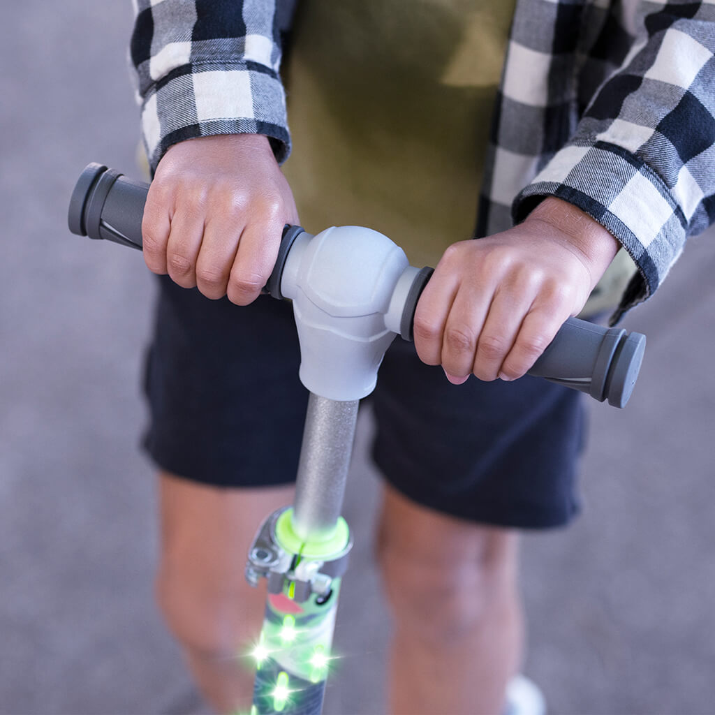 close up of a kid holding onto the handlebars on the disney grogu kick scooter