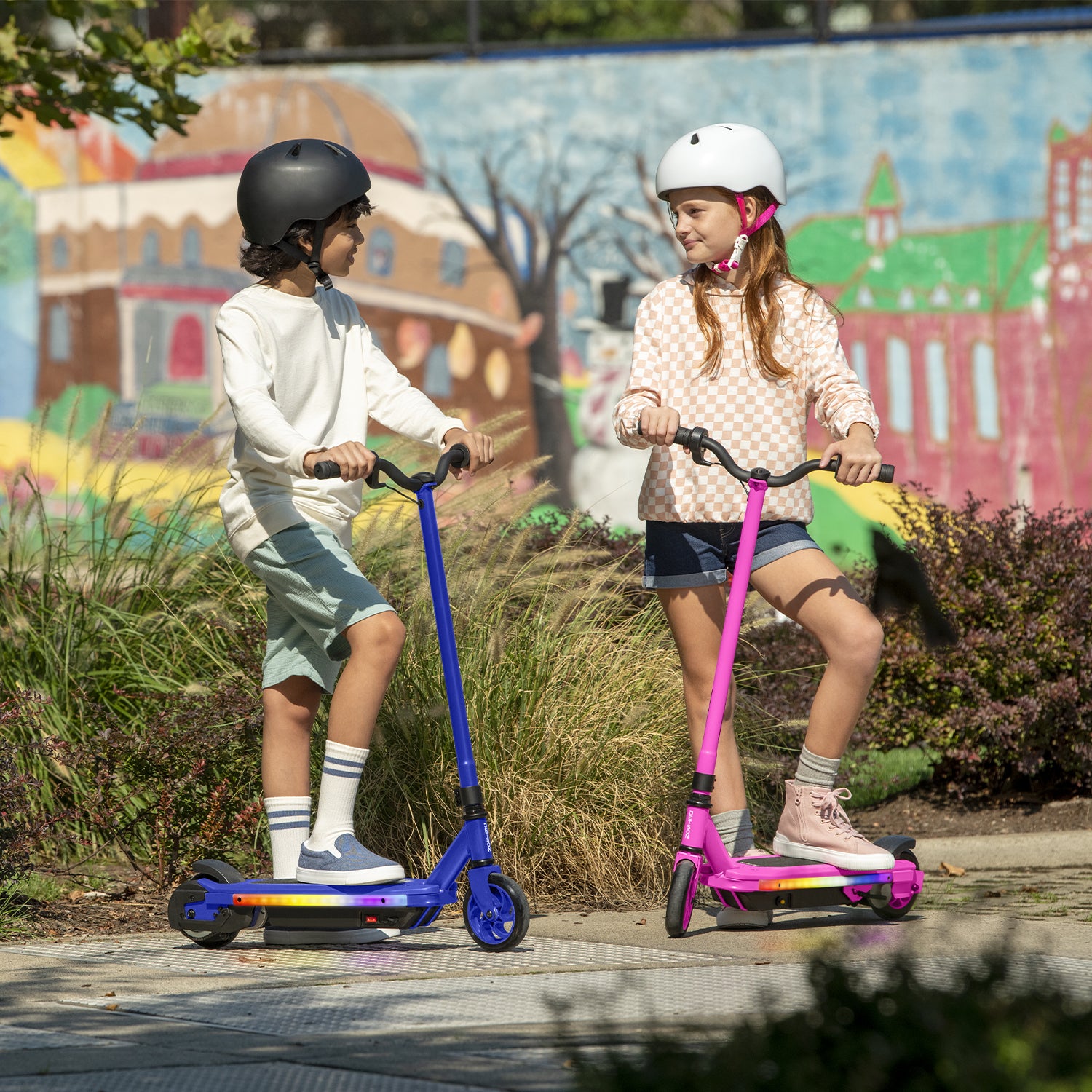 two kids standing and holding onto their echo x electric scooters