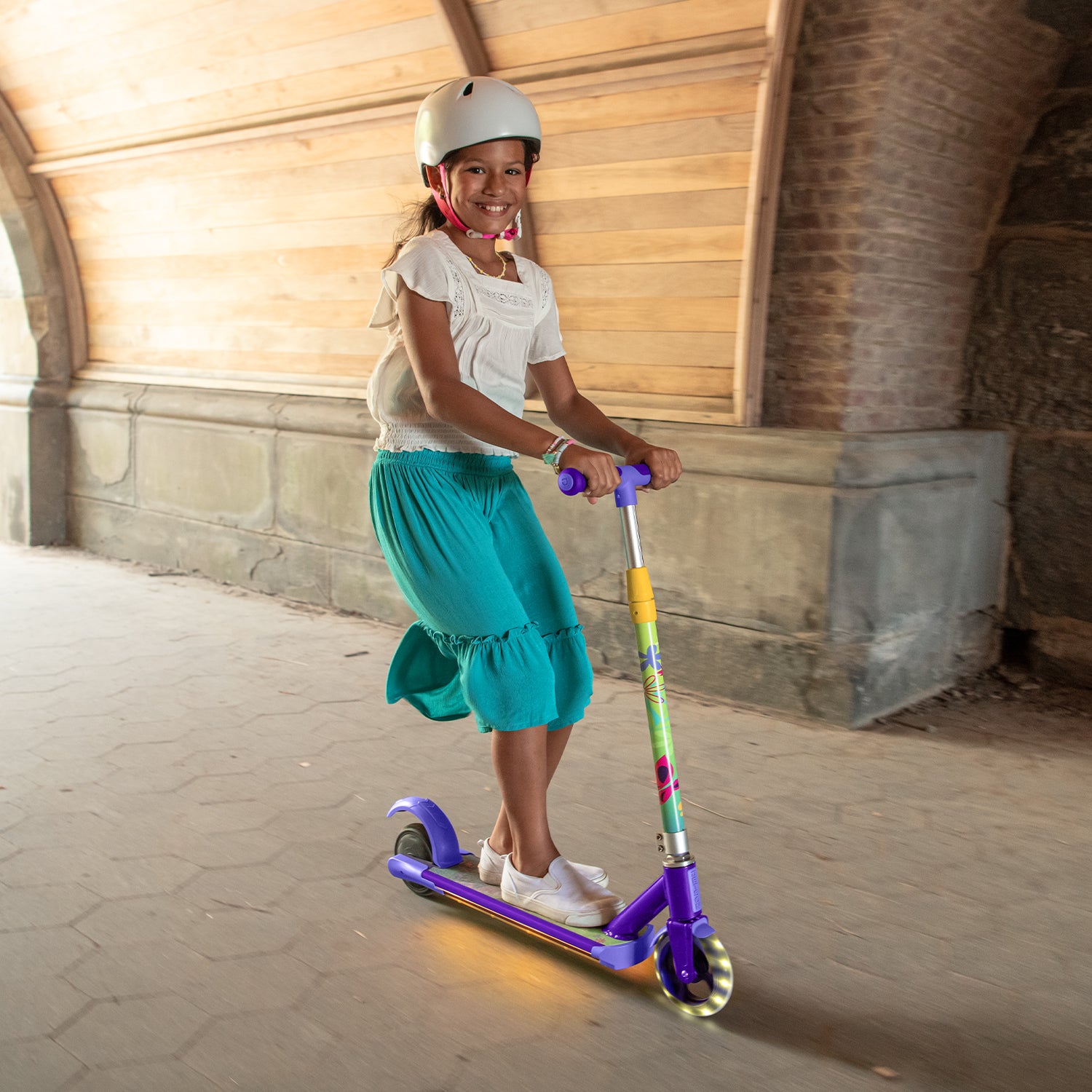 young girl riding the disney encanto electric scooter