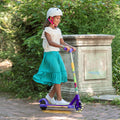 young girl riding the disney encanto electric scooter through the park