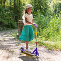 young girl riding the disney encanto electric scooter on a brick path