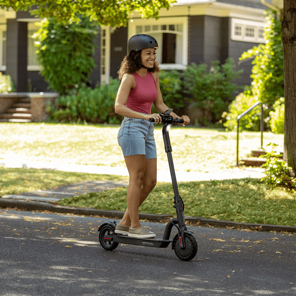 woman riding Eris scooter on a neighborhood street