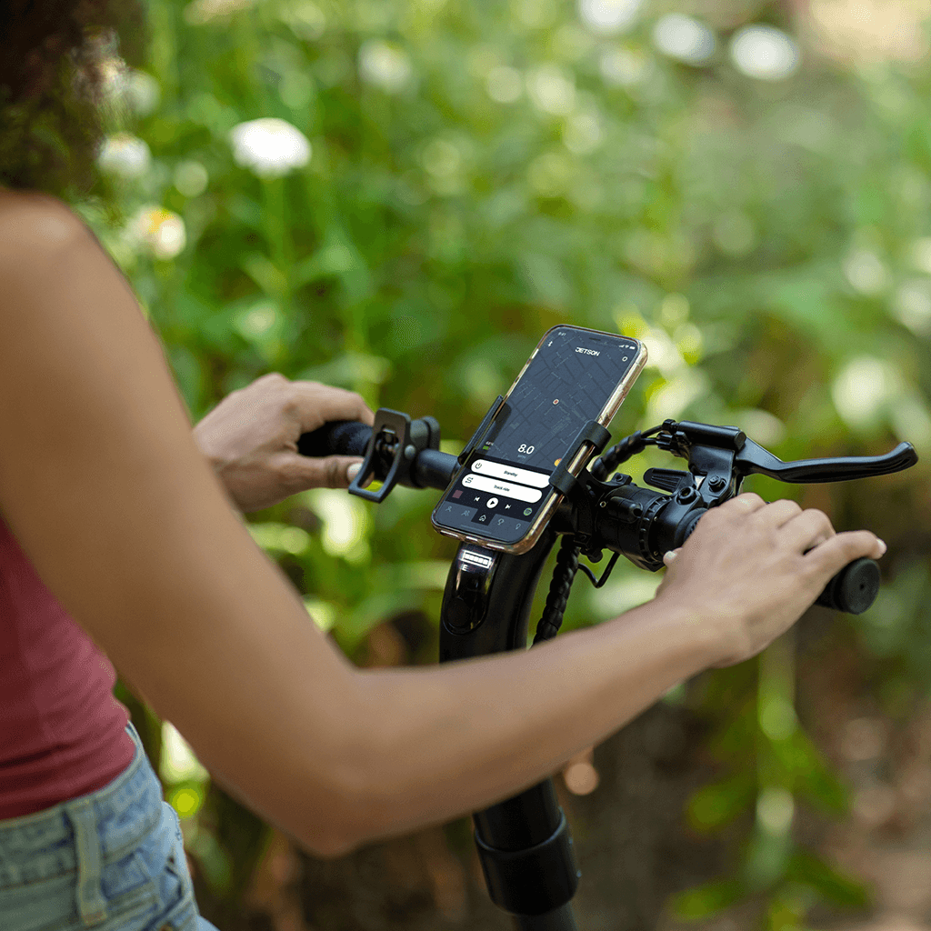 person on Eris scooter looking at their phone that is placed in the mobile device holder