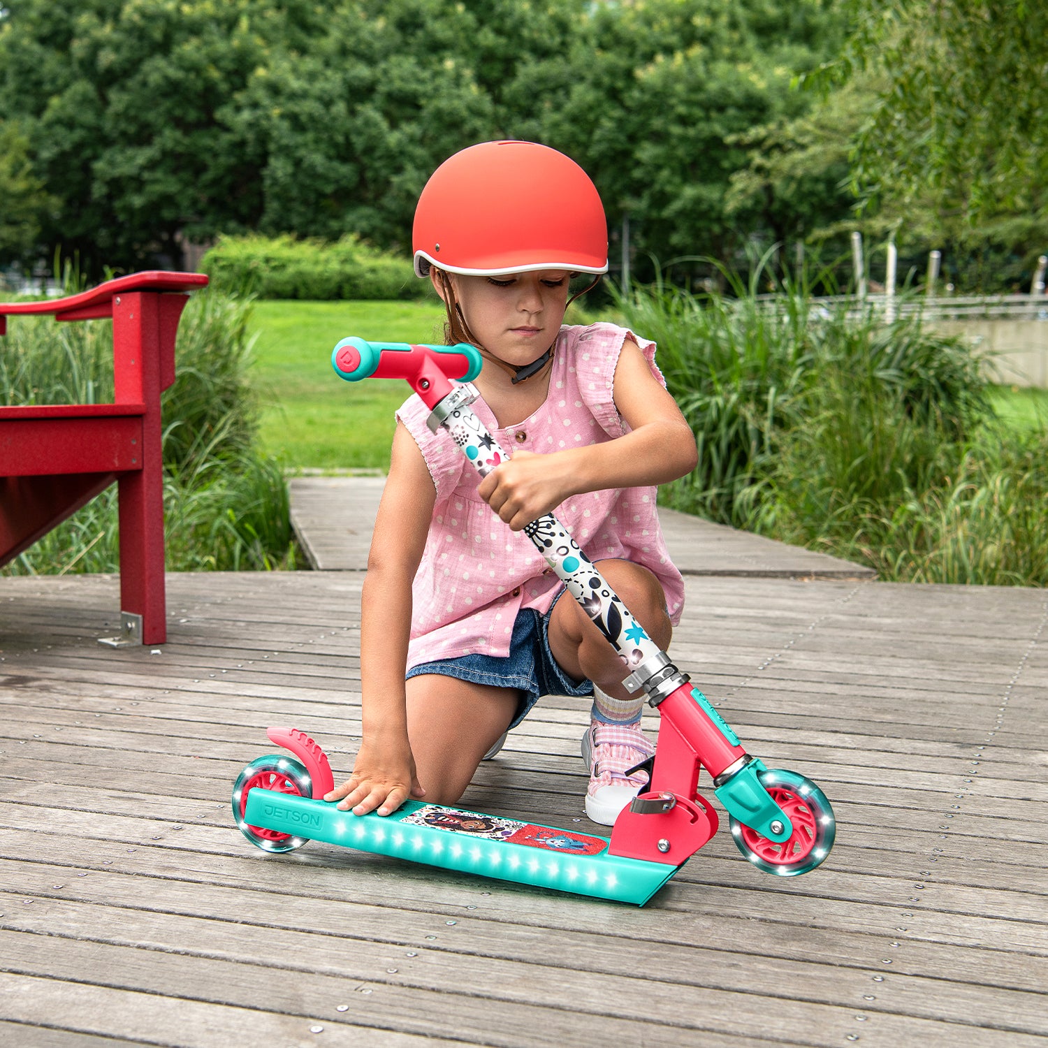young girl folding the gabby's dollhouse kick scooter