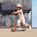young kid riding a red red gleam kick scooter 