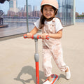 young kid riding the red gleam kick scooter 