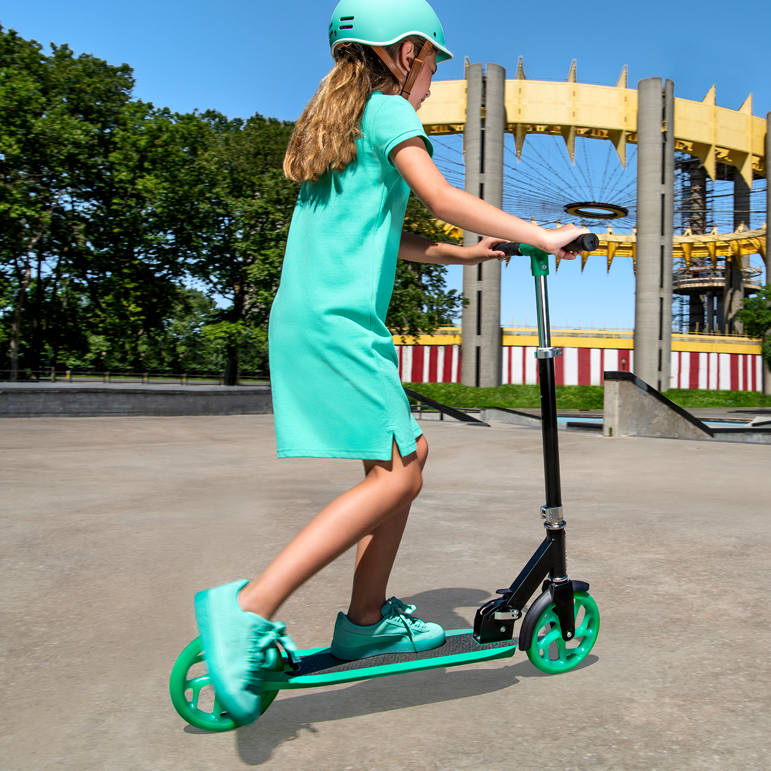 kid riding green hex scooter