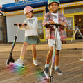 kids holding onto the black and silver helio x kick scooters