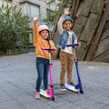 two kids holding onto pink and blue helio x kick scooters