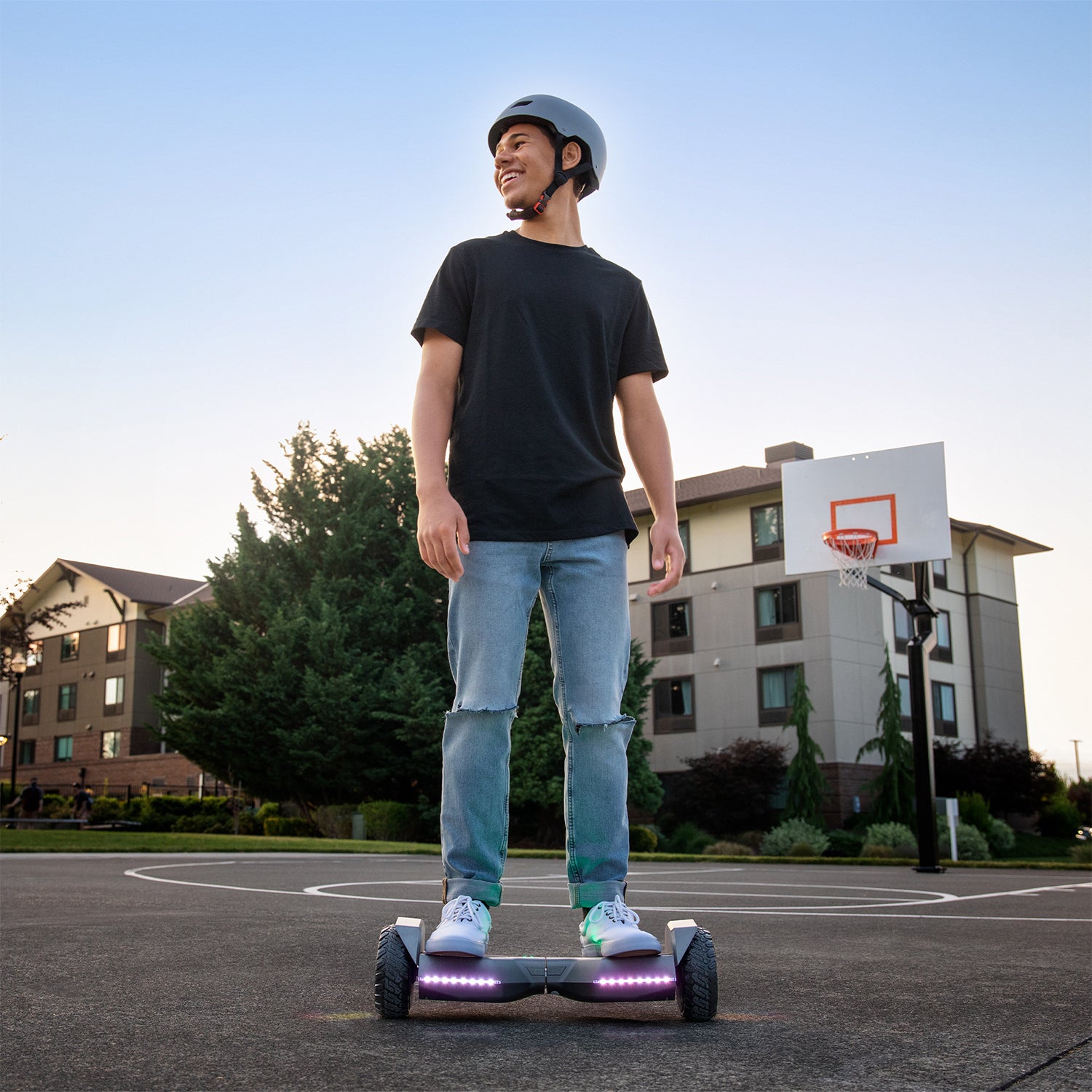 person riding gray impact hoverboard on a basketball court