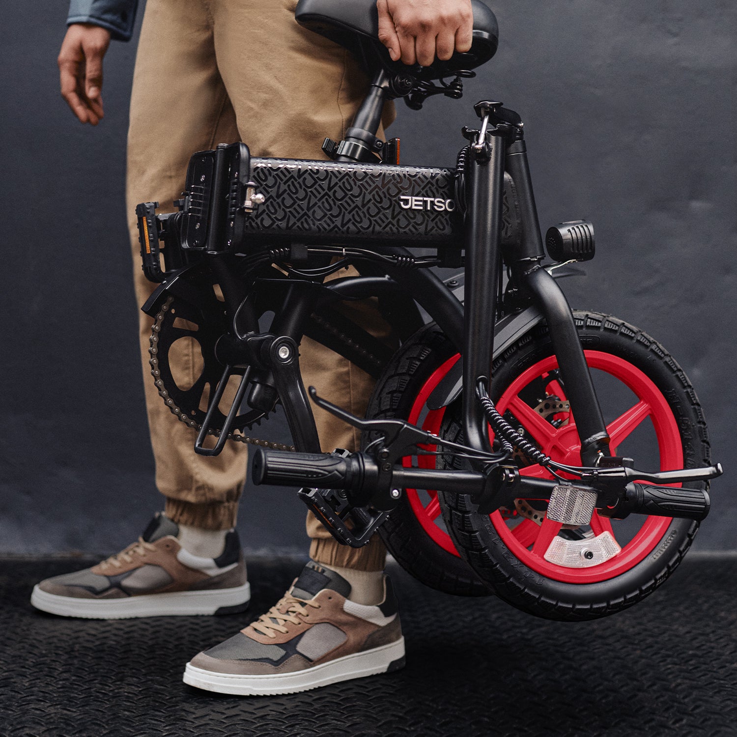 person holding the folded arro electric bike