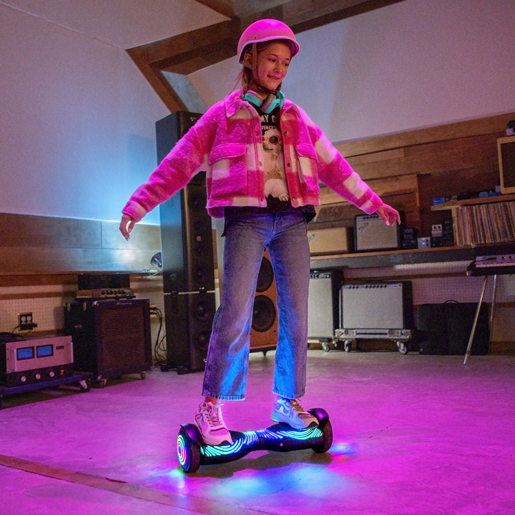 a young girl riding the J-Beat hoverboard in a room