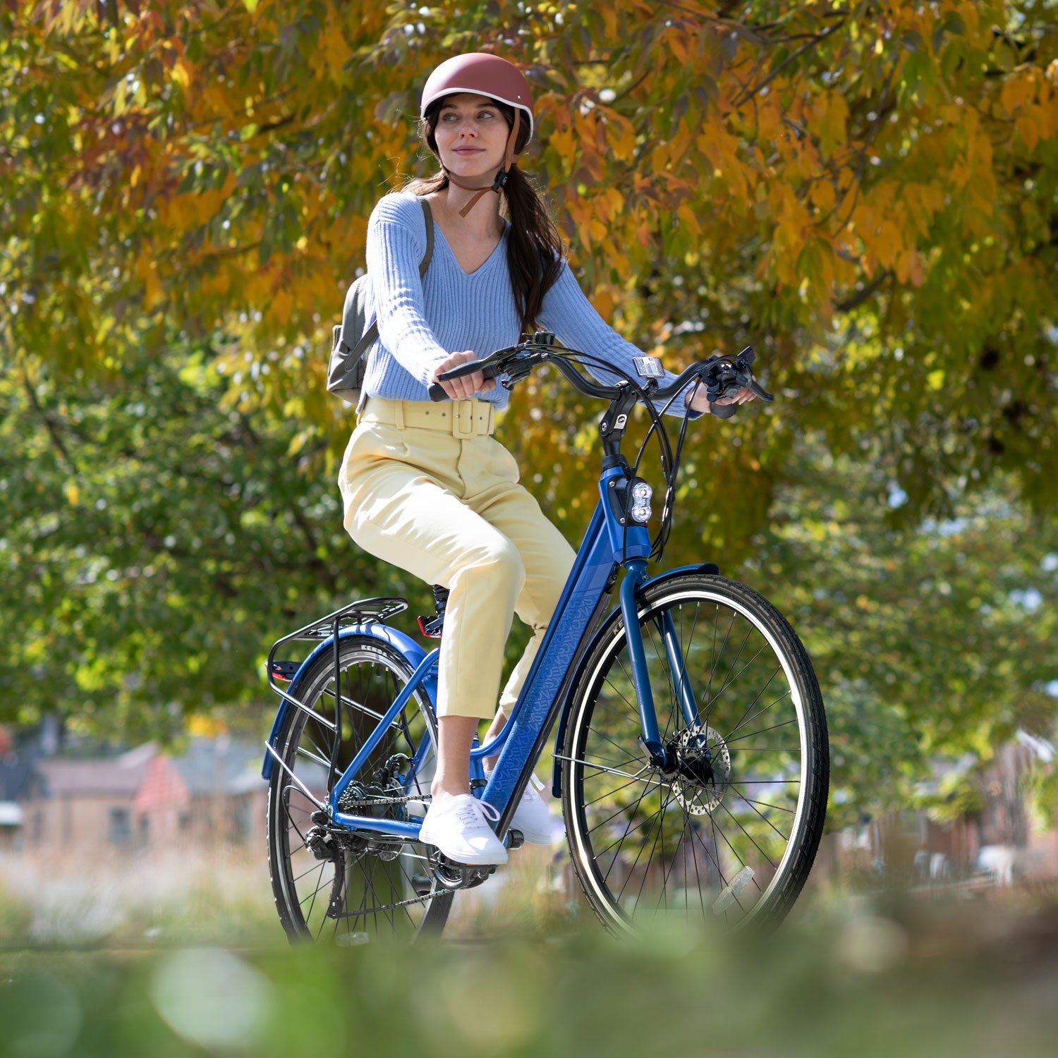 girl wearing a helmet riding the Journey electric bike through a park