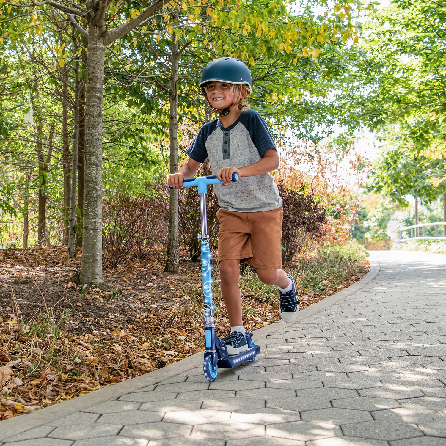 kid riding the jurassic park kick scooter along a path