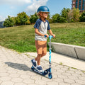 kid riding the jurassic park kick scooter through a park