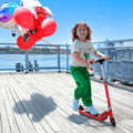 young kid riding red jupiter kick scooter on a boardwalk