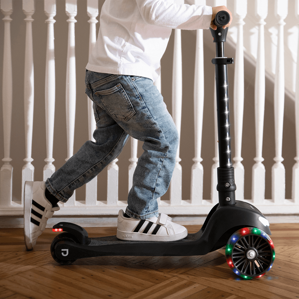 young kid riding jupiter mini kick scooter inside