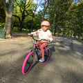 little girl riding the JLR X through the park
