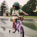 young kid riding purple light up bike