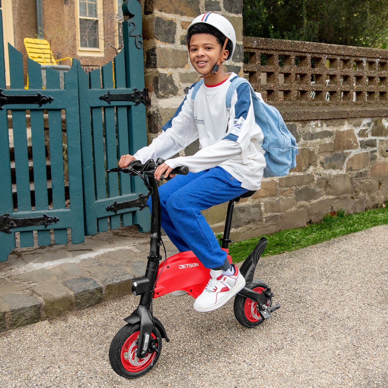 person riding the red LX10 riding in the neighborhood with a helmet on and back pack 