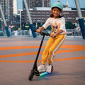 girl with helmet making turn on e-scooter