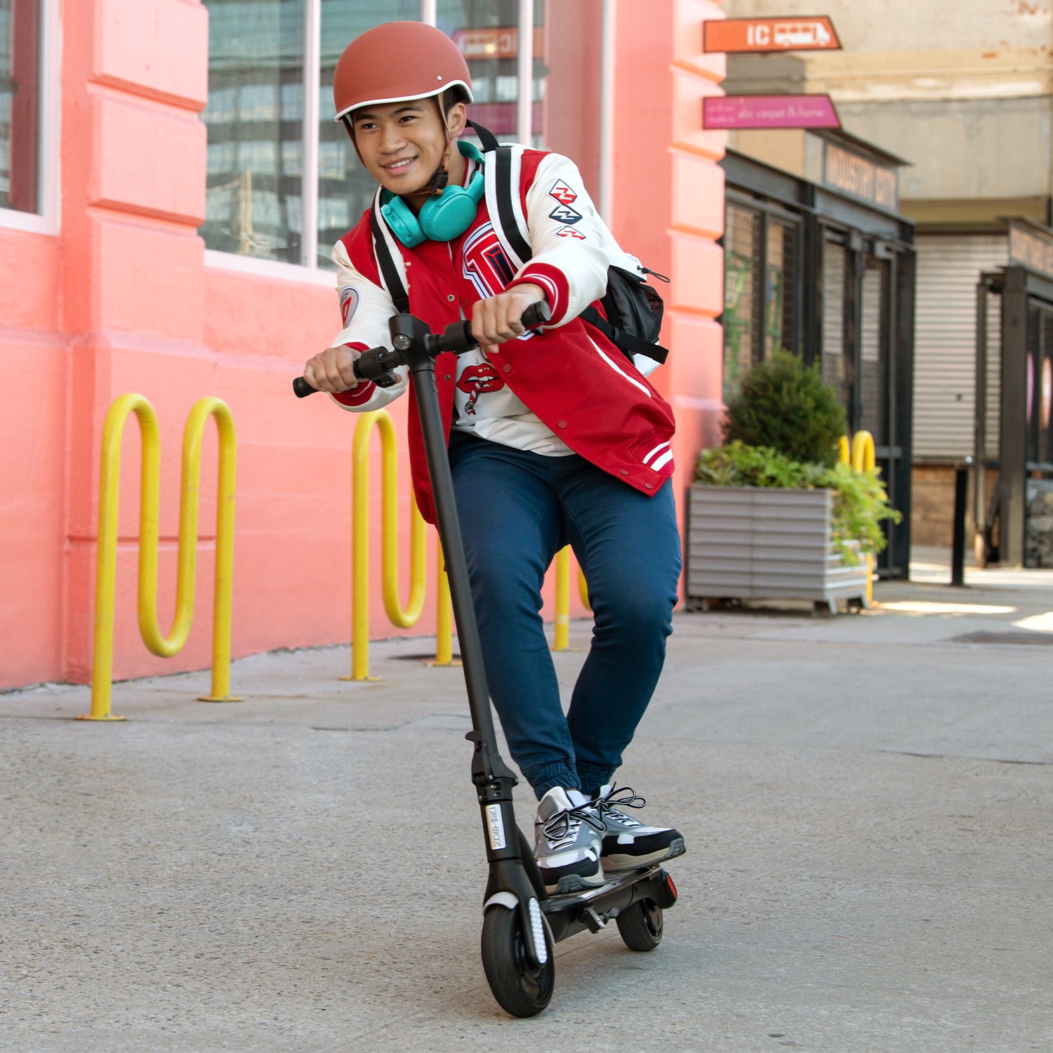 person riding the Ora Pro e-scooter outside and leaning to steer it 