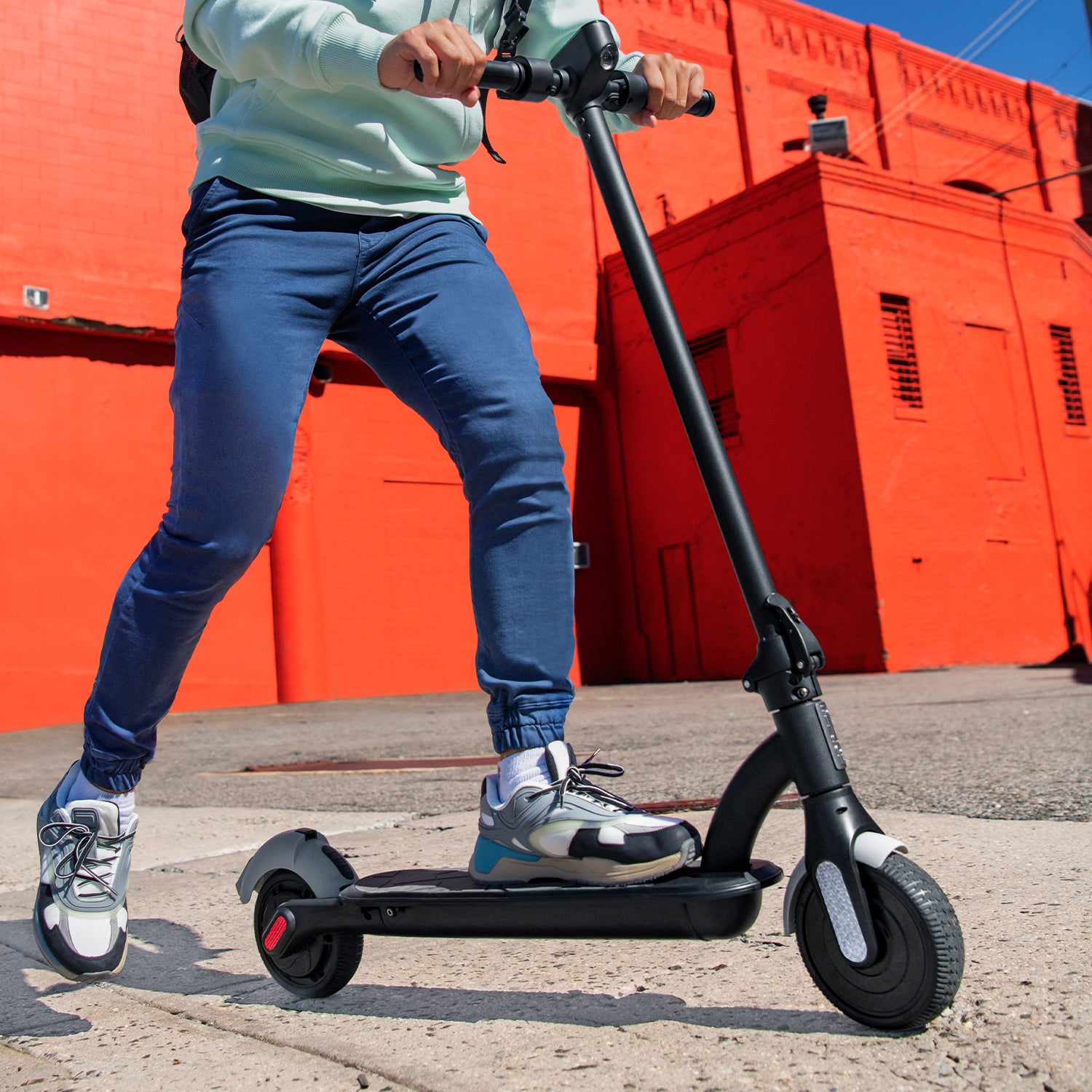 person kicking off to gain momentum on the Ora Pro e-scooter