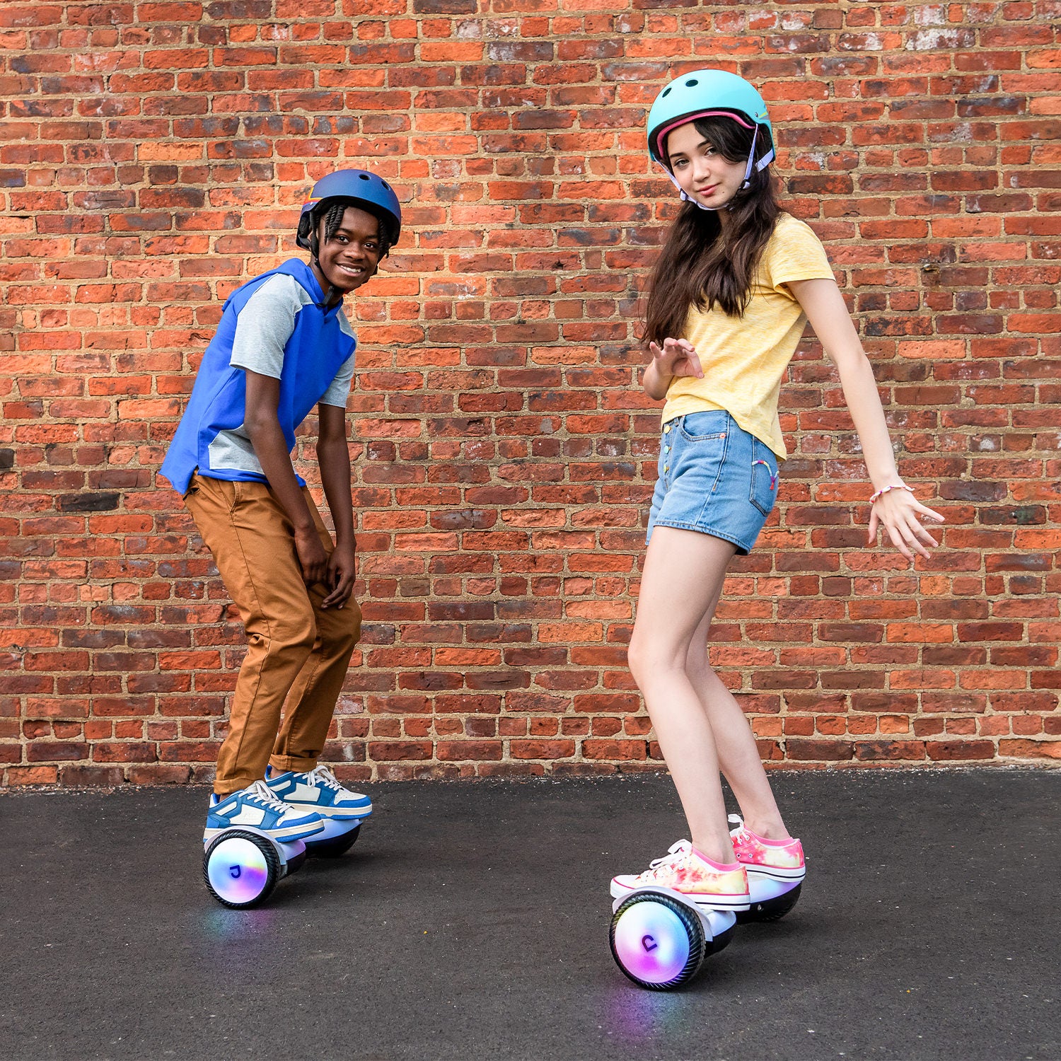 two young people having fun and riding on their Plasma X hoverboards on a street