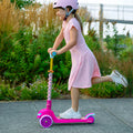 young girl riding pink princess kick scooter with leg kicked up