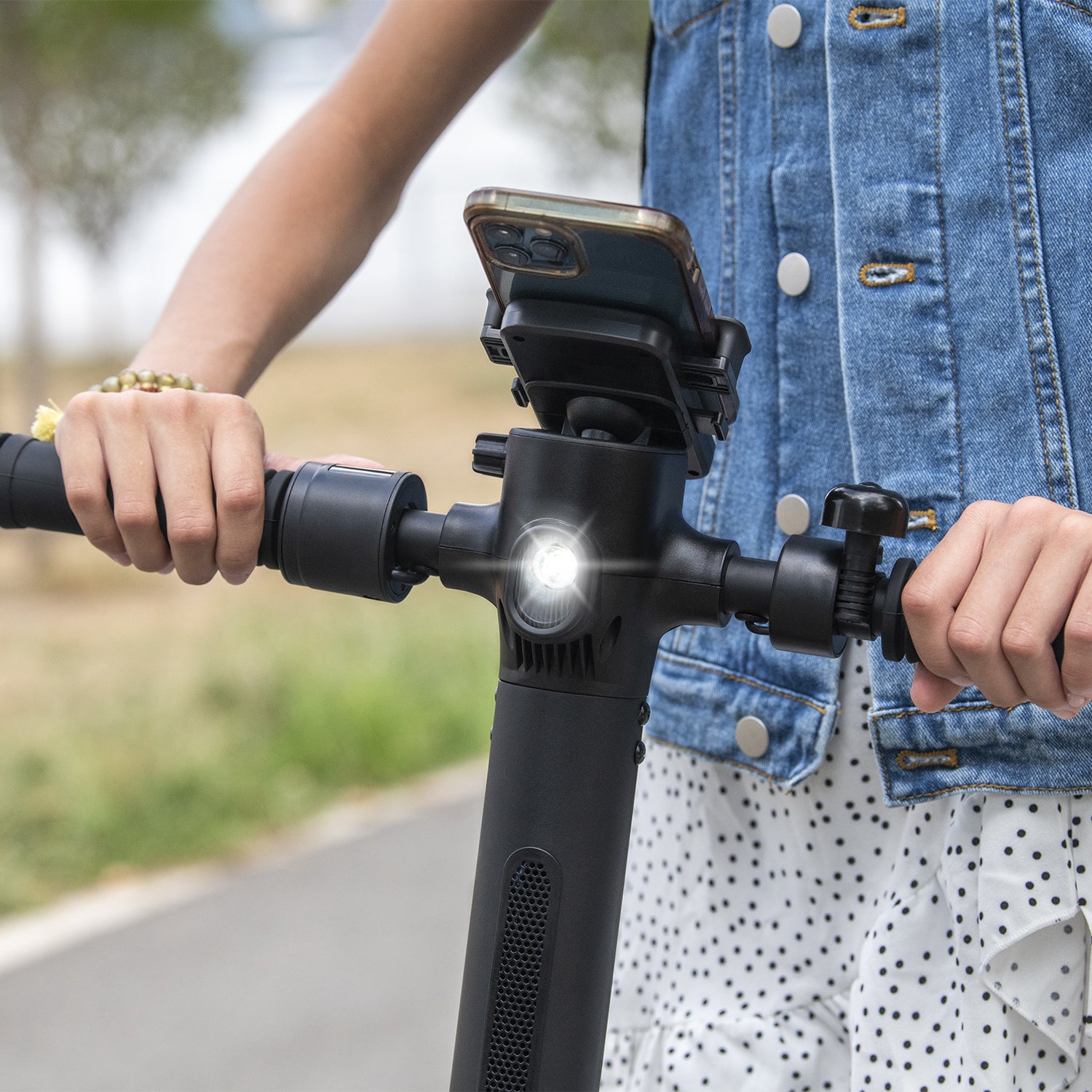 close up of front headlights and the handlebars so you can see a person's phone in the phone holder