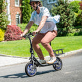 person riding Ryder e-scooter through a neighborhood